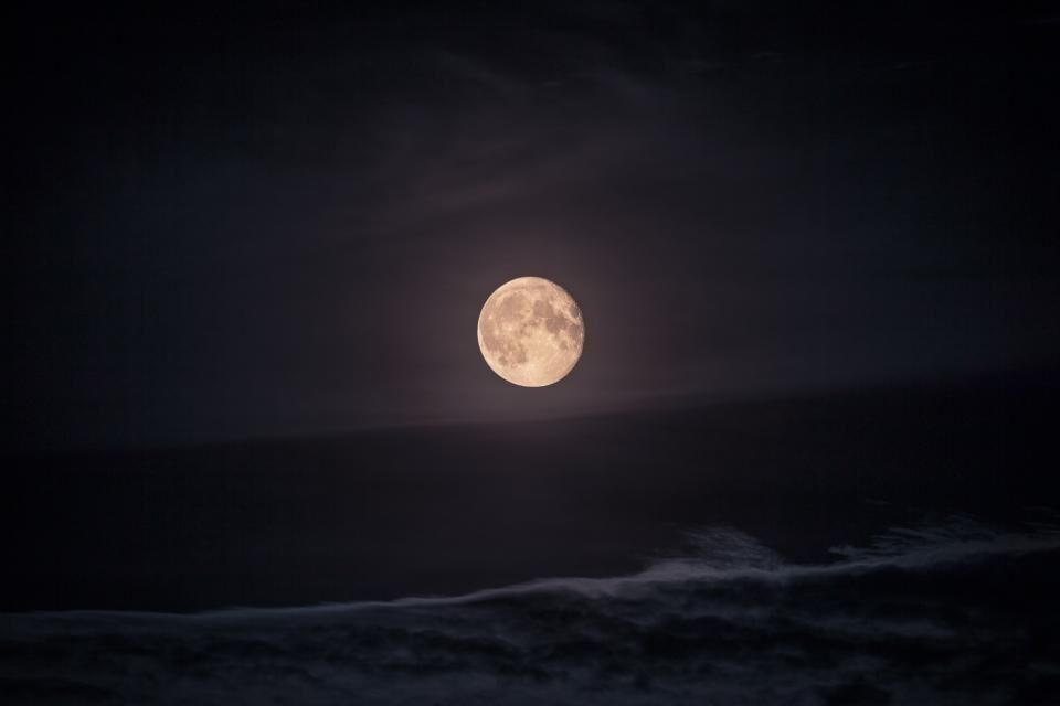 Photo d’illustration : pleine lune au-dessus d’une mer sombre