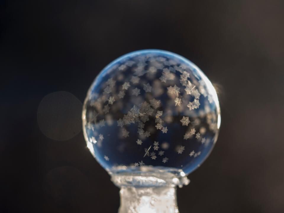 Photo d’illustration : sphère de verre givrée, motifs en étoiles, sur fond sombre