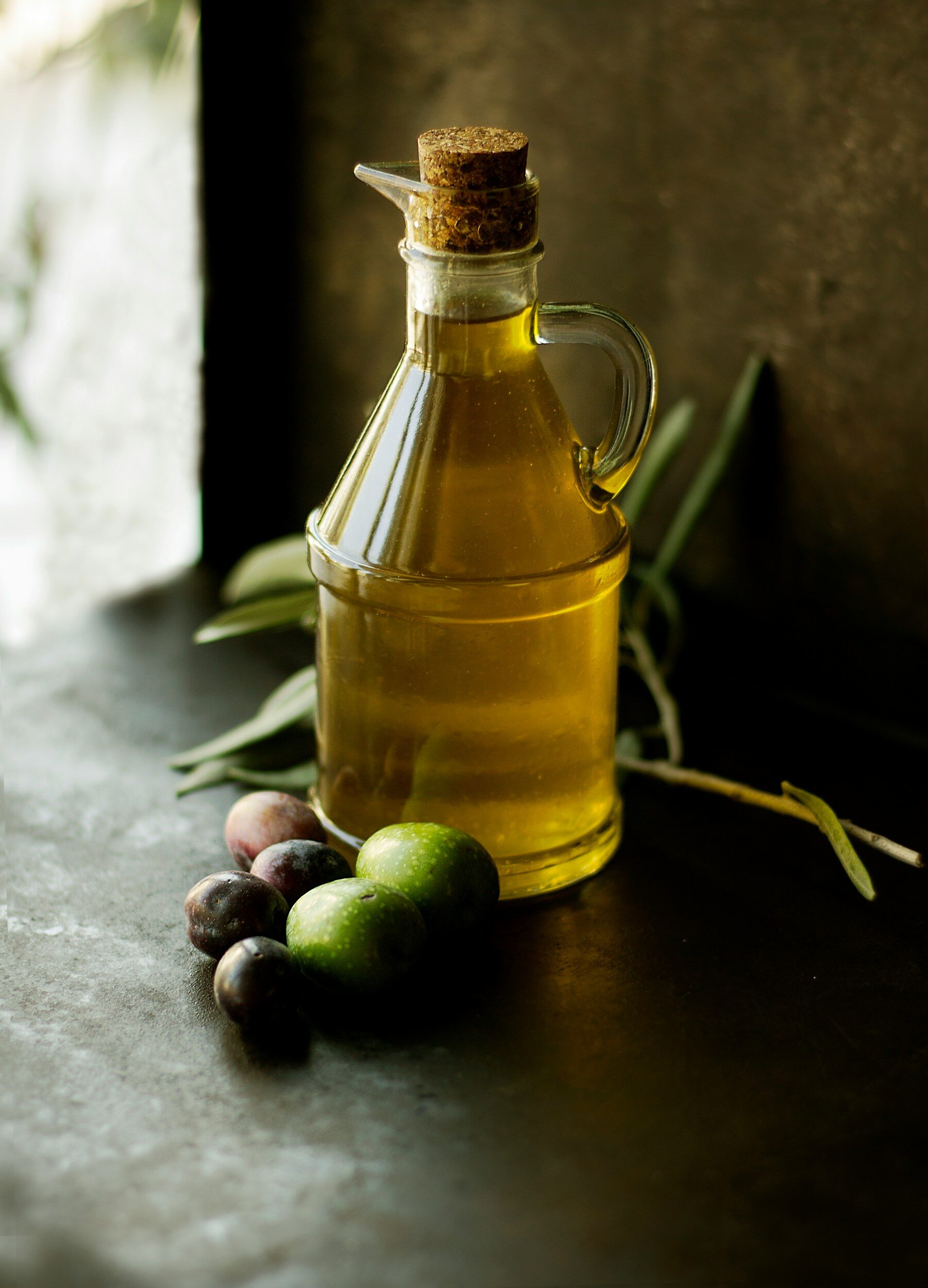 Burette d’huile d’olive et olives fraîches