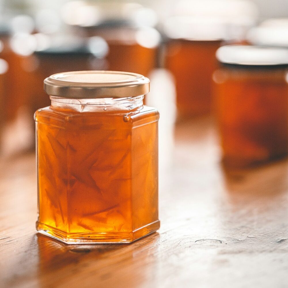 Pot hexagonal de marmelade d’agrumes sur une table en bois