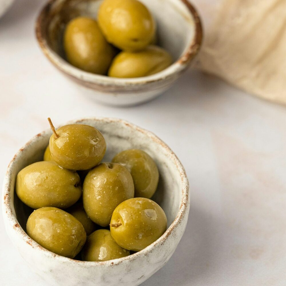 Coupelles en grès remplies d’olives vertes