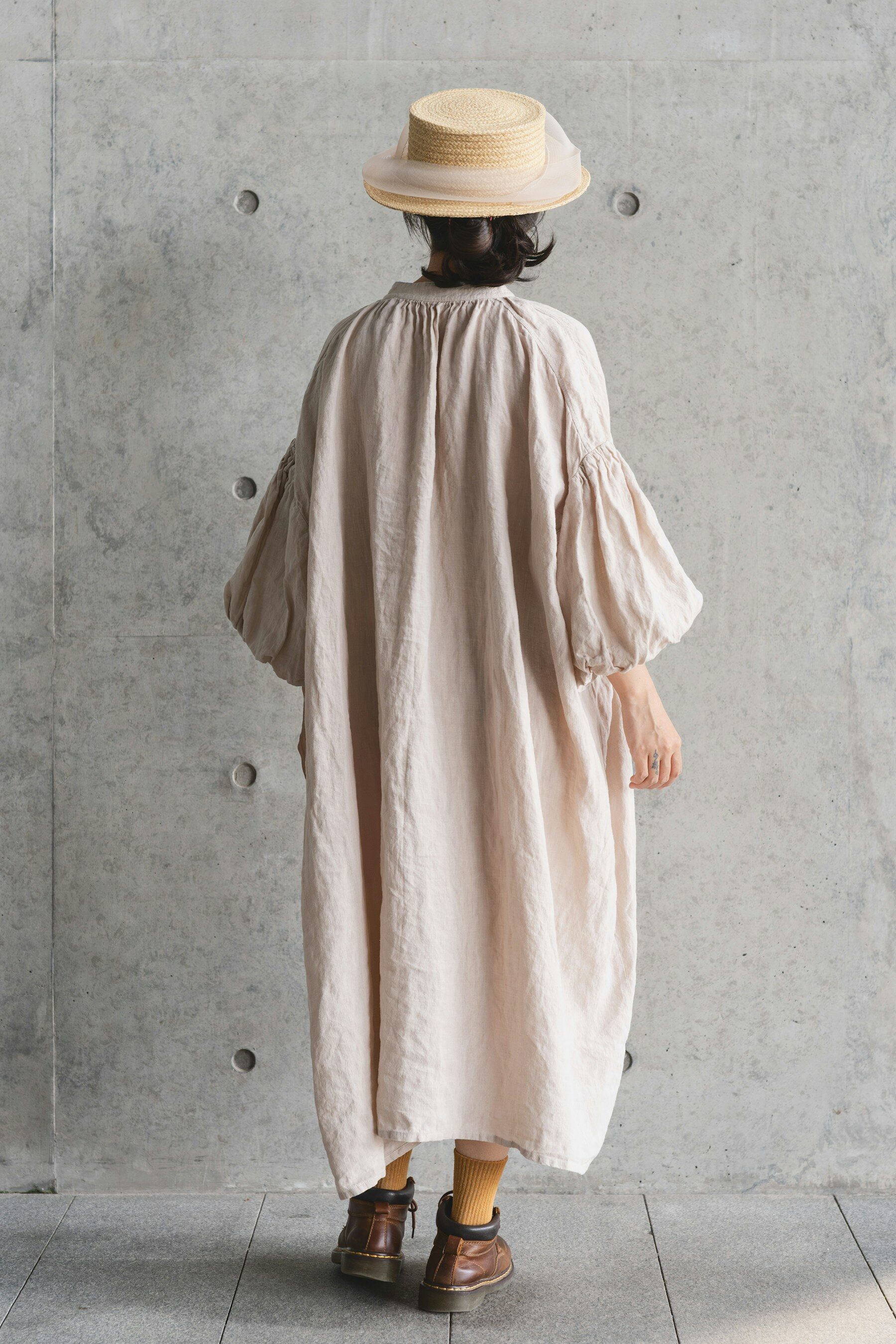 Robe longue en lin froissé, portée de dos avec un canotier
