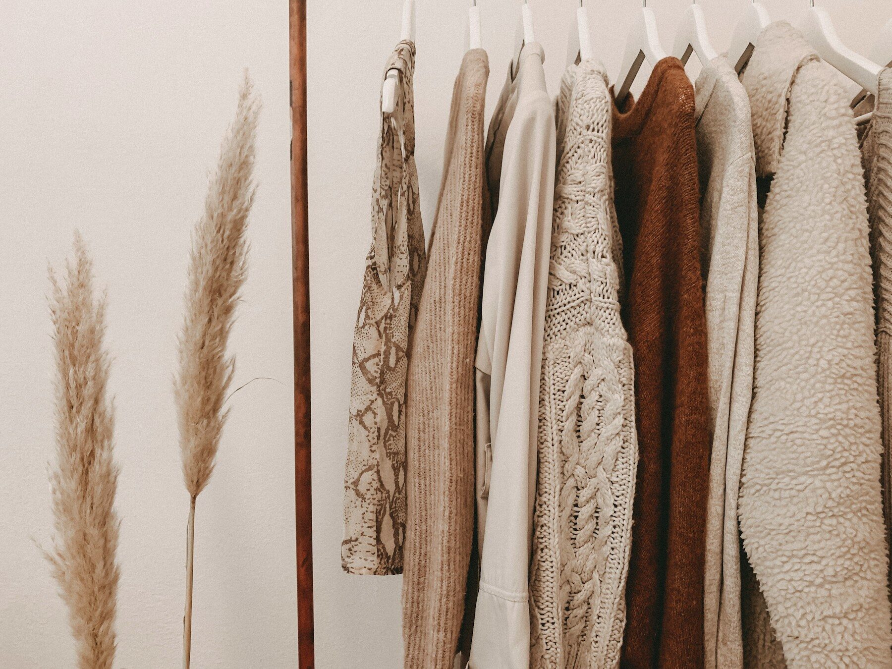 Portant de pulls en maille et de chemises aux tons naturels