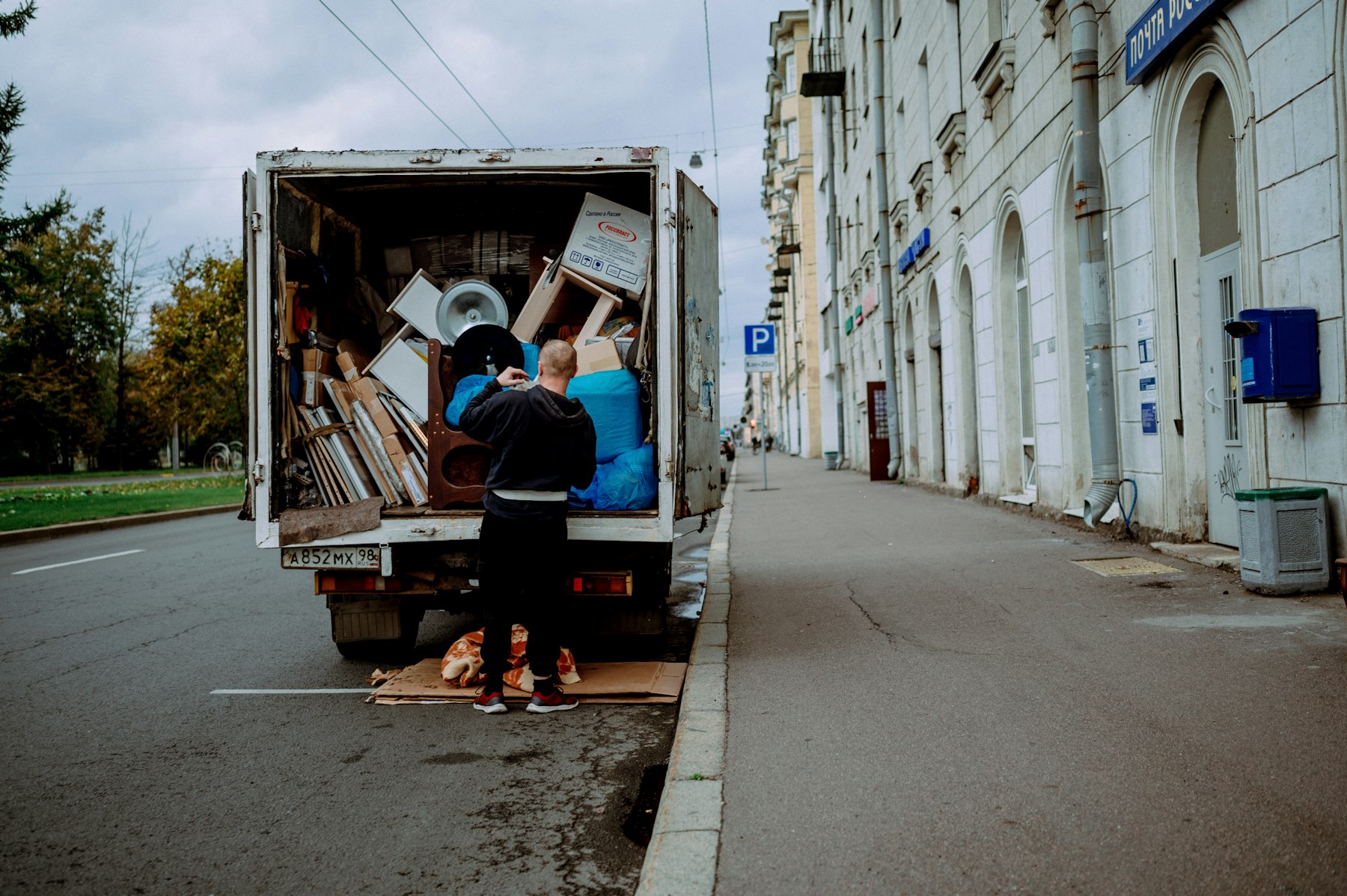 Camion de déménagement ouvert dans une rue, un déménageur charge des meubles
