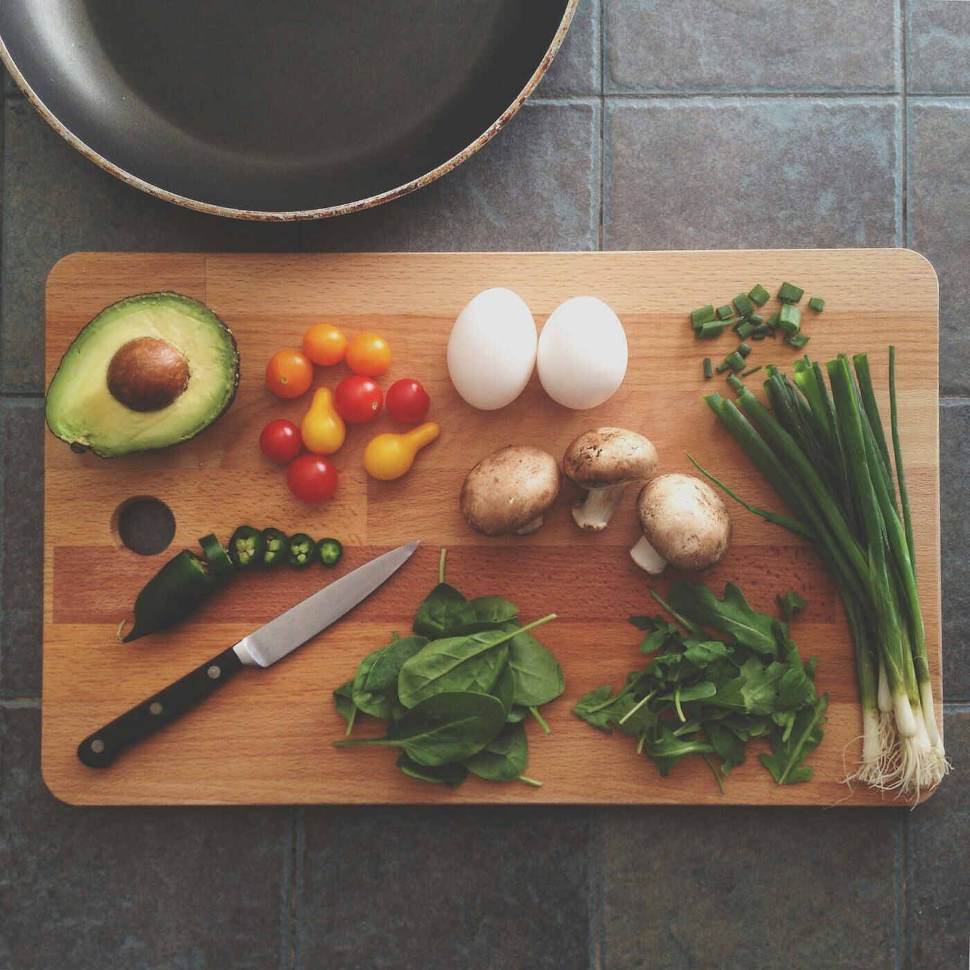 Légumes frais et couteau sur une planche à découper