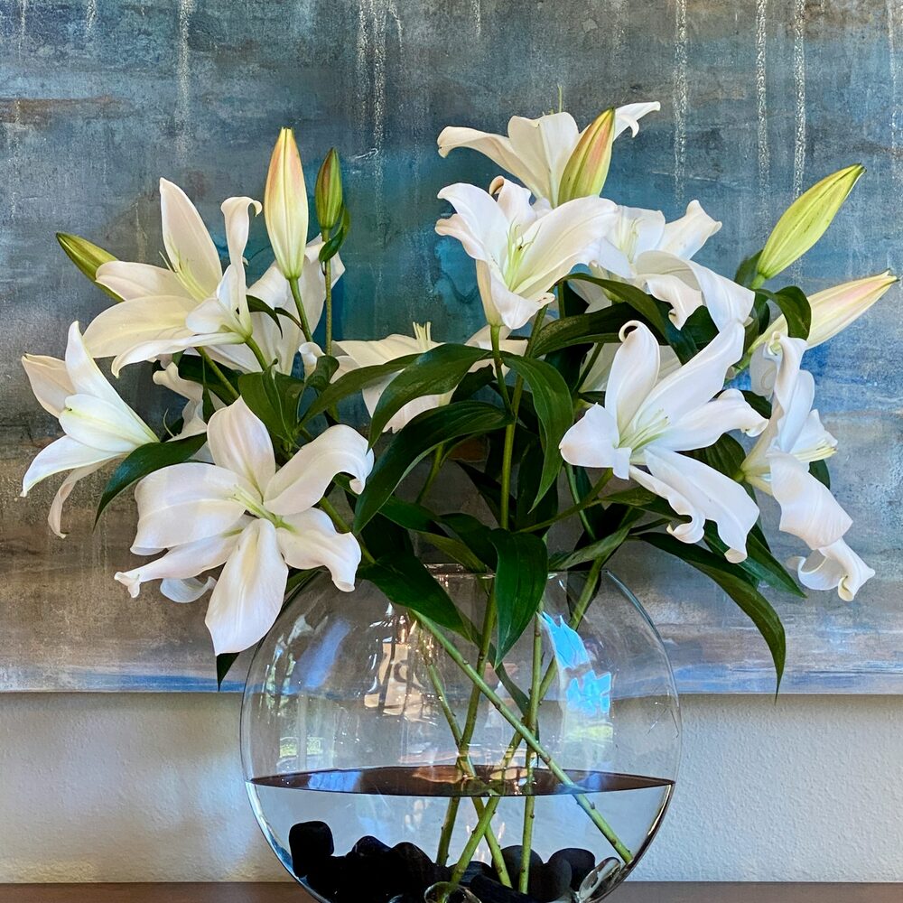 Lys blancs et feuillage dans un vase en verre