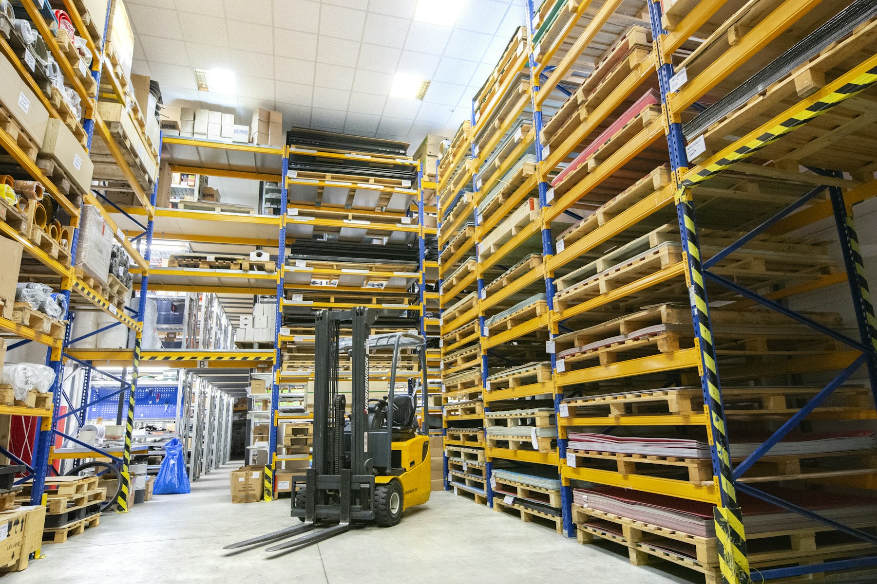 Entrepôt logistique avec palettes et chariot élévateur