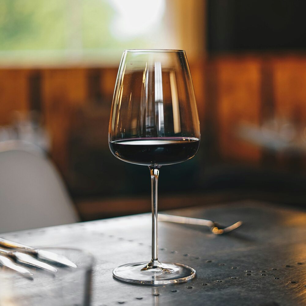 Verre de vin rouge sombre sur une table de restaurant