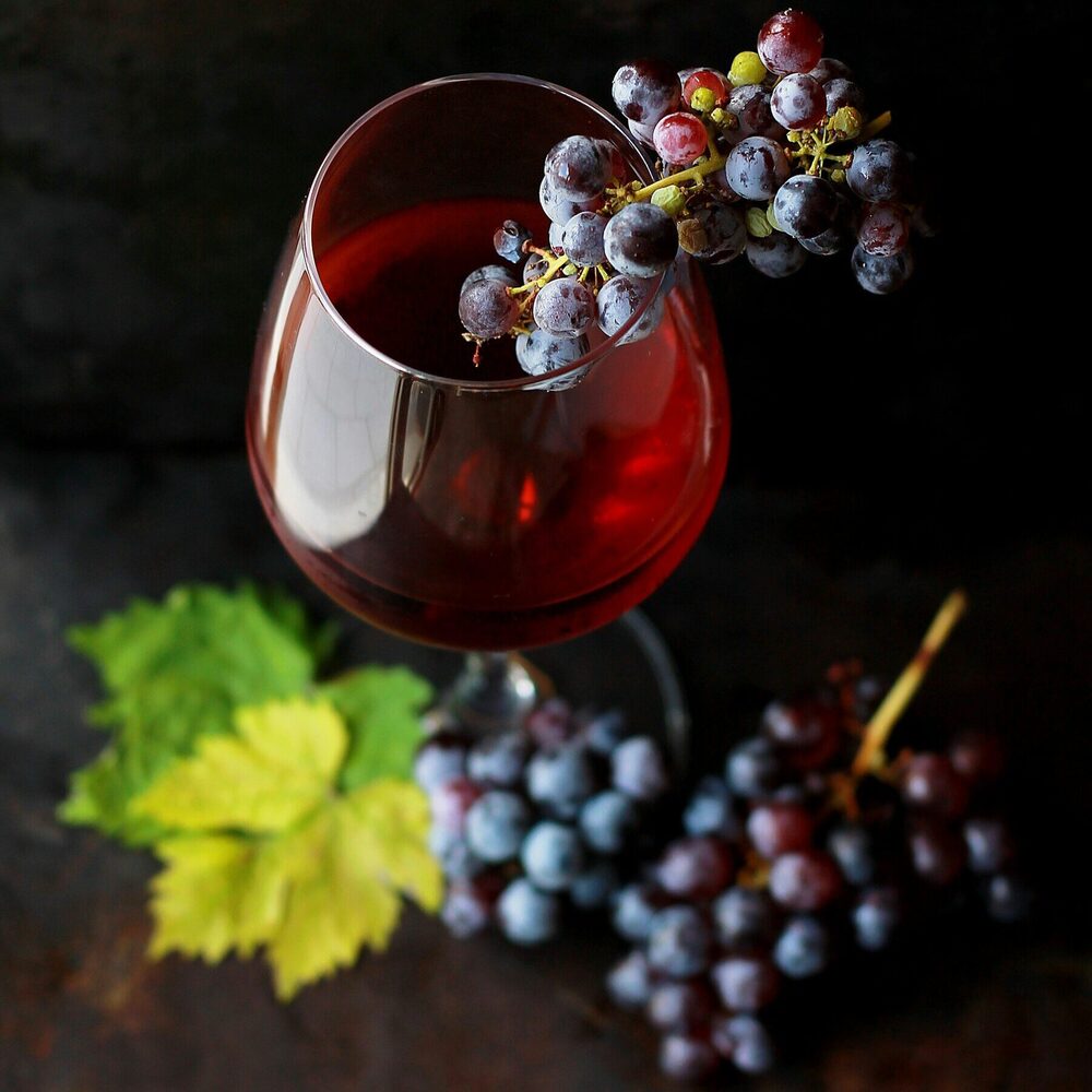Verre de vin rouge, grappes de raisin et feuille de vigne