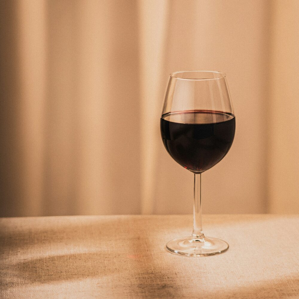 Verre de vin rouge posé sur une nappe beige