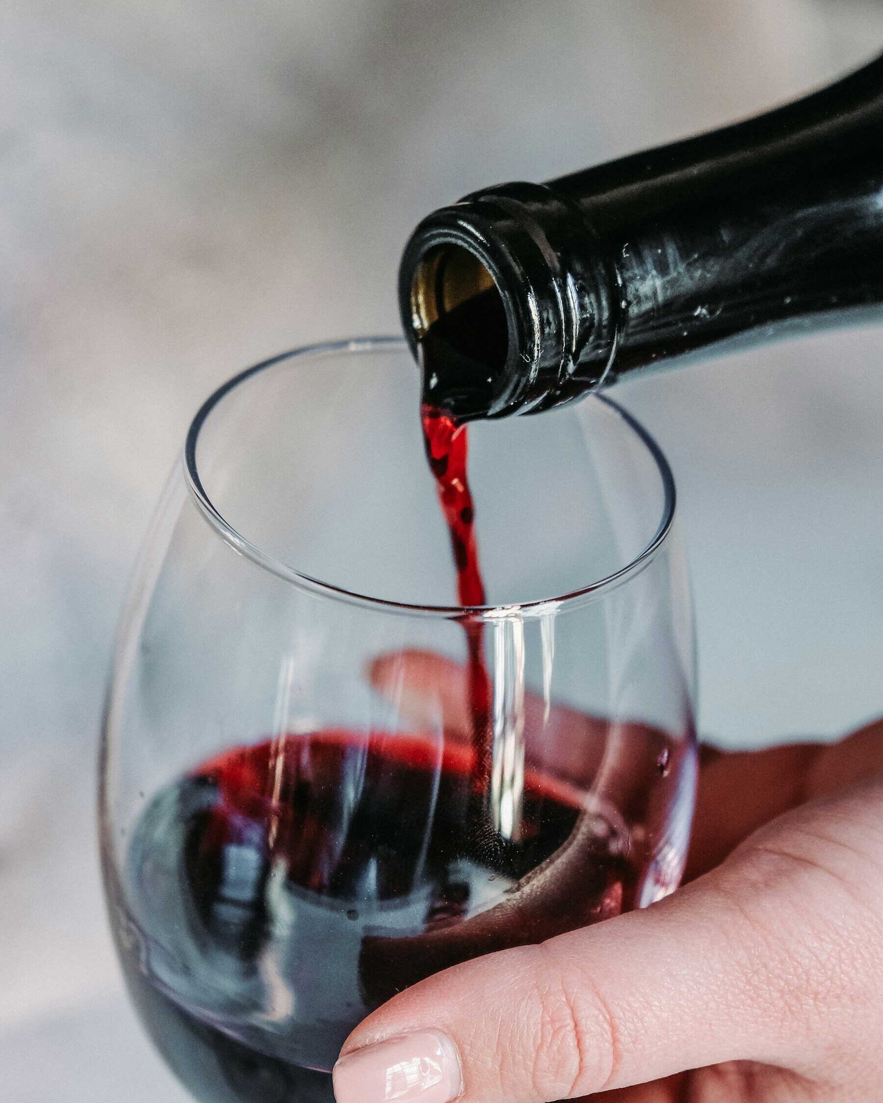 Service d’un vin rouge dans un verre, à la cave