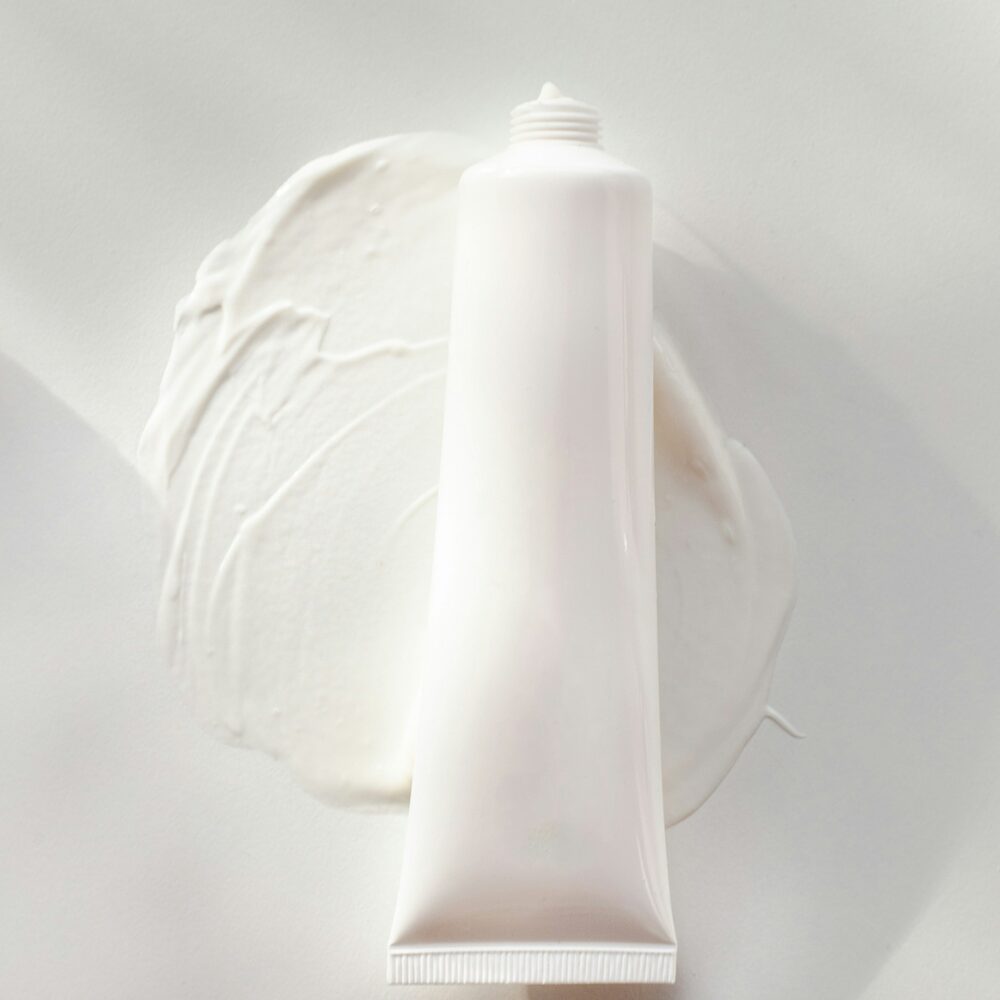 Tube blanc posé sur une touche de crème