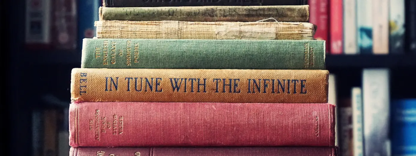 Une pile de livres anciens reliés, posée sur une table